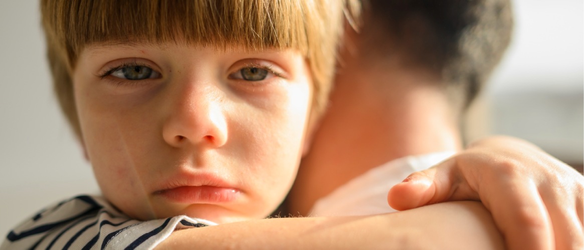 Niño llorando en brazos de su padre