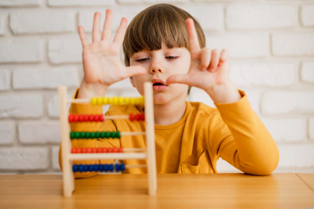 Vista frontal de un niño que usa el ábaco para aprender a contar.