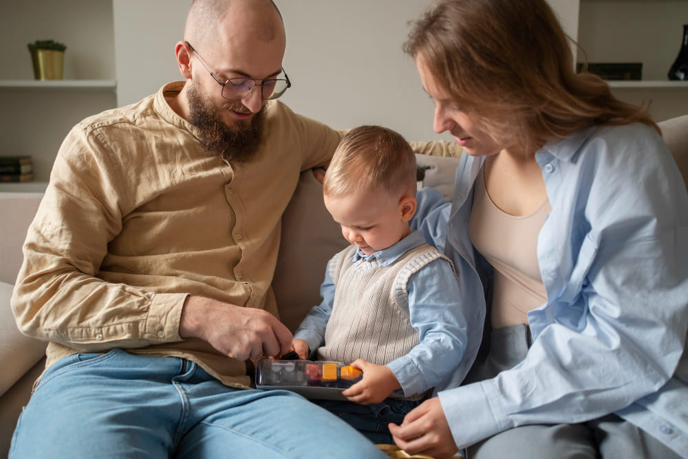 Familia jugando con su hijo en sus primeros años de vida niño juguete en mano padres observando