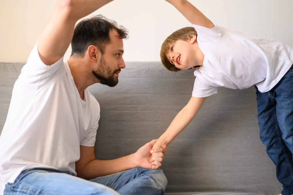 Padre e hijo jugando en el sofá de casa